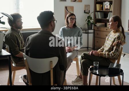 Verschiedene Gruppe junger Erwachsener, die an einer Therapiesitzung in Innenräumen teilnehmen Stockfoto
