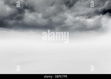 Dunkle, strukturierte Sturmwolken sammeln sich über dem offenen, nebeligen Uni in flacher Design-Illustration Stockfoto
