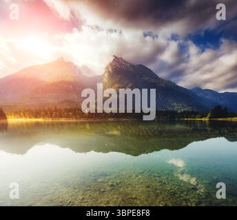 Toller Blick auf den berühmten Bergsee Hintersee, der im Sonnenlicht leuchtet. Dramatische und malerische Szene. Lage Resort Nationalpark Berchtesgadene Stockfoto