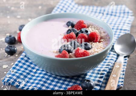 Gesunde Smoothie Schüssel mit Beeren auf Holztisch Stockfoto