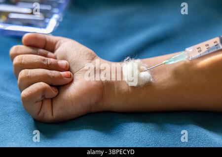 Hand erhält Injektion mit Baumwollstütze in Innenräumen Stockfoto