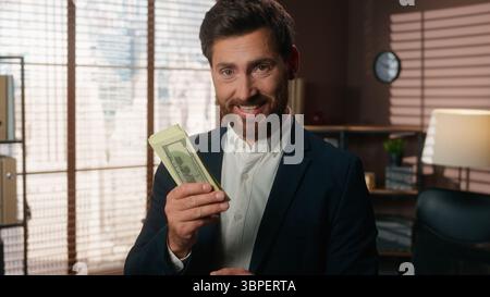 Kaukasischer Geschäftsmann mittleren Alters männlicher Geschäftsmann, der Geld hält schnüffelnd Geruch Geruch von Bargeld Happy Juoice Job finanzieller Erfolg Lächeln vor der Kamera Stockfoto