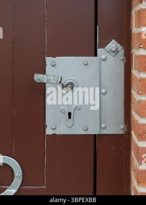Historisches Kastenschloss mit Griff und Verzierung an Holztür. Solide Details traditioneller Handwerkskunst. Kopierraum. Stockfoto