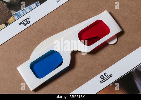 Rote und blaue 3D-Vintage-Brille isoliert auf glattem Papphintergrund mit Amityville 3D-Flyern Stockfoto