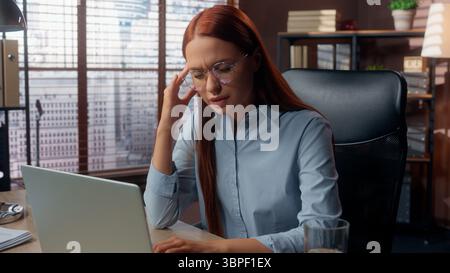 Kaukasische Geschäftsfrau im Büro Tippen Laptop Gefühl Kopfschmerzen Kopf müde überarbeitet krank kranke Geschäftsfrau weibliche Mädchen Arbeiterin Arbeit bei Stockfoto