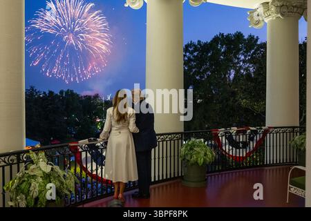 Präsident Donald Trump und First Lady Melanie Trump sehen ein Feuerwerk vom 4. Juli über der National Mall vom Blue Room Balcony. Stockfoto