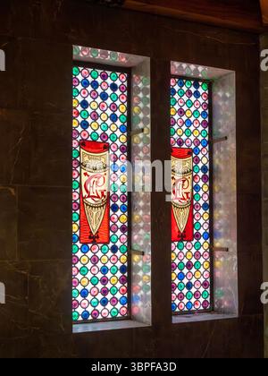 Detail eines Buntglasfensters mit den Initialen von Eusebi Güell in Antoni Gaudí Palau Güell Villa in Barcelona, Spanien. Stockfoto