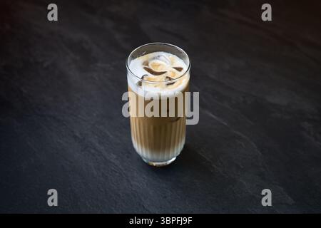 Eiskaffee in hohem Glas auf dunklem Hintergrund Stockfoto