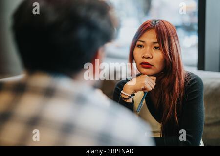 Zwei Geschäftspartner, die ein fokussiertes Gespräch in einer zwanglosen, modernen Umgebung führen Stockfoto