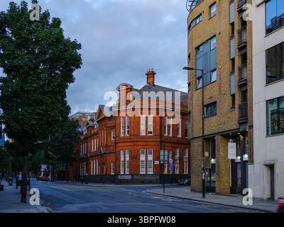 Vereinigtes Königreich, London, 09. Juli 2025. Eine ruhige Straßenecke in East London mit einem markanten edwardianischen Backsteingebäude, umgeben von modernen Wohnhäusern Stockfoto