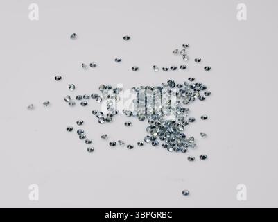 Verstreute natürliche blaue Saphire-Sammlung auf hellgrauem Hintergrund, Edelsteine, Schmuckherstellung, funkelnde Kristalle, lebendige Farbe, Nahansicht Stockfoto