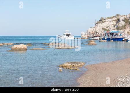 Malerischer Blick auf die Küste mit türkisfarbenem Wasser, felsigen Formationen und Booten, die in der Nähe des Ufers ankern und die ruhige Schönheit eines Sommertages bei Th festhalten Stockfoto