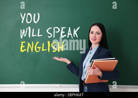 Lehrer, der auf Text zeigt, sprechen Sie Englisch auf grüner Tafel. Sprachkurs Stockfoto