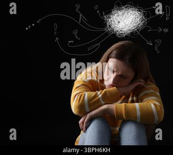Besorgte Frau auf schwarzem Hintergrund. Verwirrte Gedanken wie Kritzeleien über ihrem Kopf. Stress, Angst, Depression Stockfoto