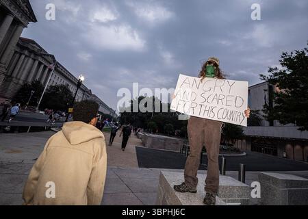 Washington DC – Demonstranten halten Schilder während der Parade zum 250. Geburtstag am 14. Juni 2025, die einen Fitnesswettbewerb am Morgen, eine Präsentation von Panzern, Hubschraubern und historischen Waffen in der National Mall, eine Fallschirmdemonstration und ein Feuerwerk beinhaltete. Am selben Tag, dem 79. Geburtstag von Präsident Trump, fanden landesweit Proteste unter dem Banner „No Kings“ gegen die Politik der Regierung statt. Stockfoto