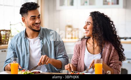 Glückliches junges arabisches Paar genießt ihr Frühstück zusammen Stockfoto