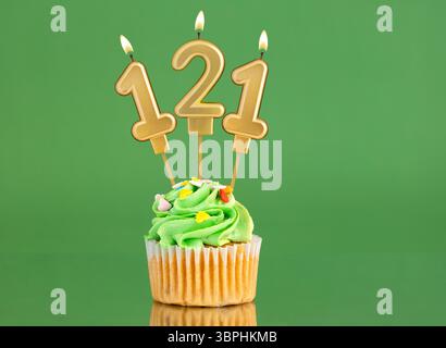 Nummer 121 Geburtstagskerze - Cupcake auf grünem Hintergrund Stockfoto