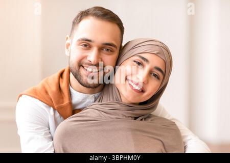 Fröhliche Junge Muslimische Paar Umarmt Posiert Im Haus Stehend Stockfoto