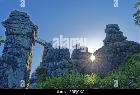 Die Morgensonne scheint durch eine Öffnung in den Externsteinen. Die Externsteine, eine rund 40 Meter hohe Sandsteinformation in der Teutoburg Stockfoto
