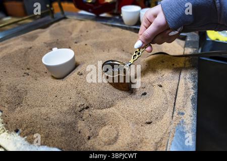 Türkischer Kaffee im Sand zubereitet, türkischer Kaffee vom Straßenverkäufer zubereitet Stockfoto