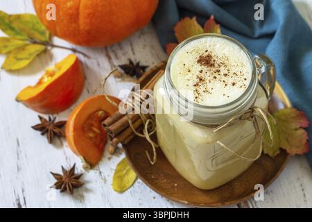 Herbstgetränk. Kürbis gewürzte Latte oder Kaffee im Glas auf einem rustikalen Holztisch Stockfoto