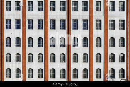 Die rot-weißen Fliesen einer mehrstöckigen Fabrikfassade mit Fensterscheiben, Frankfurt am Main, Deutschland, Europa Stockfoto