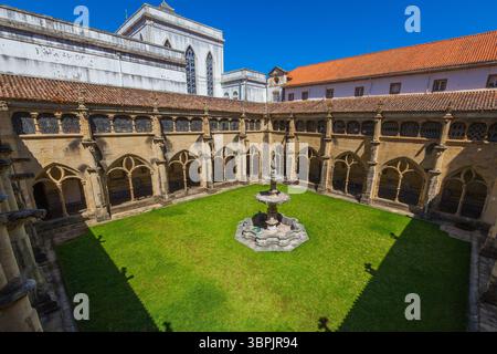 Ein malerischer Innenhof mit einem zentralen Steinbrunnen, umgeben von gotischen Bögen und lebendigen Fliesenmalereien, vor einem Hintergrund der Geschichte Stockfoto