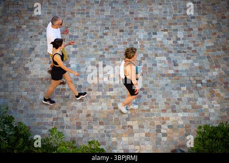 Outdoor-Aktivitäten, die einen gemütlichen Spaziergang auf historischen Pflasterpflastern machen und gemeinsam die bezaubernden Straßen der Stadt erkunden. Stockfoto