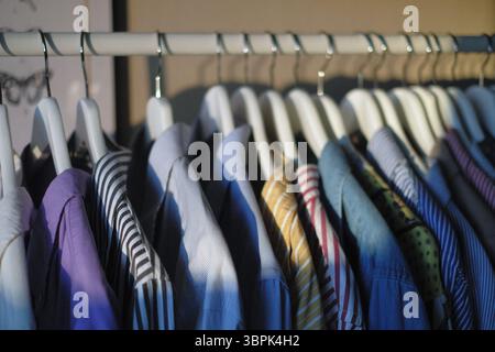 Hemden hängen an Kleiderbügeln an einem Kleiderständer hintereinander Stockfoto