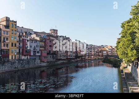 Der onyar River fließt friedlich durch girona und spiegelt die lebhaften Farben der Häuser am Ufer wider, wodurch eine malerische Szene im Katalon entsteht Stockfoto