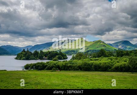 Ein Blick auf das Grün in der Nähe von Derwentwater von Keswick aus umrahmt die ruhige Umgebung an bewölkten Tagen mit weit entfernten Hügeln, darunter die Catbells auf der anderen Seite Stockfoto
