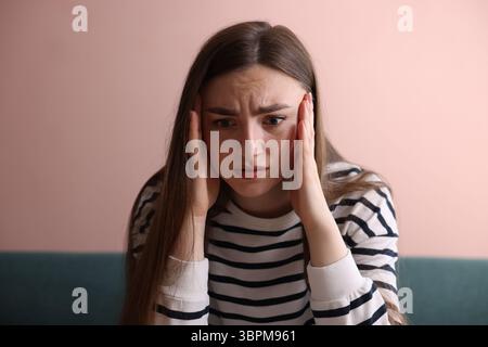 Verängstigte Frau, die zu Hause an Paranoia leidet Stockfoto