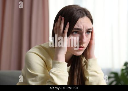 Verängstigte Frau, die zu Hause an Paranoia leidet Stockfoto