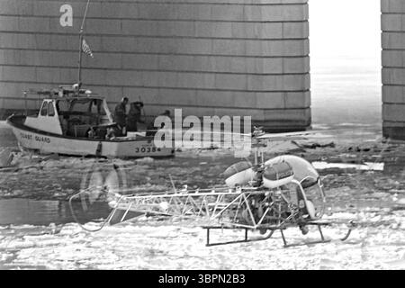 14. Januar 1982, Washington, DC, Vereinigte Staaten: Such- und Rettungsteams der US-Küstenwache bergen Leichen von Opfern des Air Florida Fluges 90 aus den gefrorenen Gewässern des Potomac River, während ein Police Bell 47 Hubschrauber am 14. Januar 1982 in Washington, D.C. hilft. Der Inlandsflug der US-amerikanischen Passagierflugzeuge stürzte nach einem Zusammenstoß mit der 14th Street Bridge am 13. Januar 1982 mit 74 Menschen. (Bild: © Richard Ellis/ZUMA Wire) Stockfoto