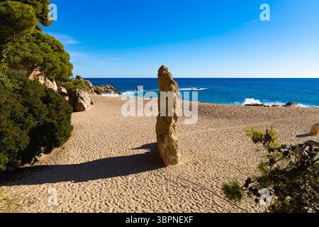 Die berühmte Felsformation Cavall Bernat steht hoch am Sandstrand von Platja d'Aro, mit einem klaren blauen Himmel, tiefblauem Meer und grünem Mittelmeer Stockfoto