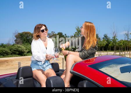 Freundinnen diskutieren gerne über den Sommer und sind bereit zum Feiern. In der Nähe gibt es Platz für Werbetexte Stockfoto