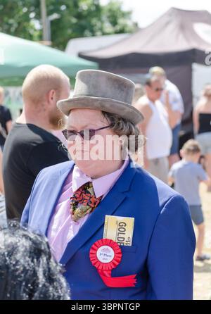 Eine Frau verkleidet als Willy wonka auf einem Dorffest mit dem goldenen Ticket in ihrer oberen Tasche UK Stockfoto