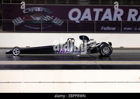 Motion Blur Drag Racing bei Nacht, bei dem Autos auf der Rennstrecke mit Zuschauern in der Nähe konkurrieren Stockfoto