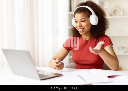 Junge schwarze Frau, die an einem Online-Kurs oder einem Remote-Meeting mit Laptop teilnimmt Stockfoto