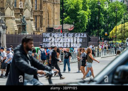 London, Großbritannien. Juli 2025. Eine kleine Demonstration mit einem Plakat mit der Aufschrift "die Menschen in Gaza bitten um Hilfe der Welten" für Palästina vor dem Parlament während des Staatsbesuchs von Präsident Macron in London. Guy Bell/Alamy Live News Stockfoto