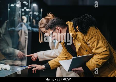 Zwei Personen, die eine Museumsausstellung genau untersuchen Stockfoto