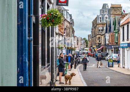 Blick auf Menschen und Geschäfte in North Berwick High Street, East Lothian, Schottland, Großbritannien Stockfoto