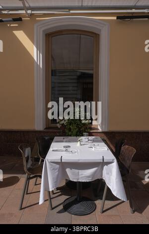 Ein bezauberndes Restaurant im Freien mit elegantem Tisch und einladendem Ambiente Stockfoto