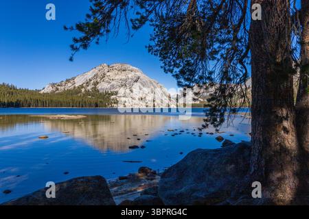 Ruhiger See, der Berge unter einem klaren blauen Himmel reflektiert Stockfoto