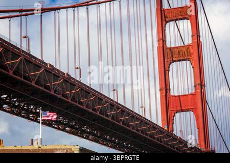 Flacher Blick auf die Golden Gate Bridge mit amerikanischer Flagge, die in San Francisco winkt Stockfoto