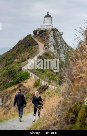 Ein paar zu Fuß in Richtung Nugget Point Lighthouse, Otago, South Island, Neuseeland Stockfoto