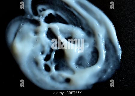 Formlose Zahnpasta-Färbung auf schwarzem Hintergrund. Stockfoto