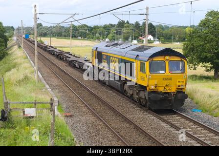 Eine GBRf-Lokomotive der Baureihe 66 führt einen intermodalen Zug durch Prestbury Crossing in Cheshire. Stockfoto