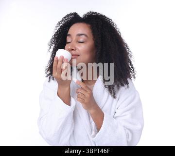 Schöne brasilianische Frau mit einem Glas Kollagencreme auf weißem Hintergrund Stockfoto