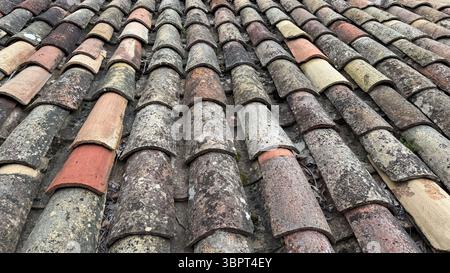 Nahaufnahme von gealterten Terrazzofliesen, typisch für historische europäische Gebäude. Die verwitterte Oberfläche und natürliche Farbvariationen erzeugen eine rustikale Stockfoto
